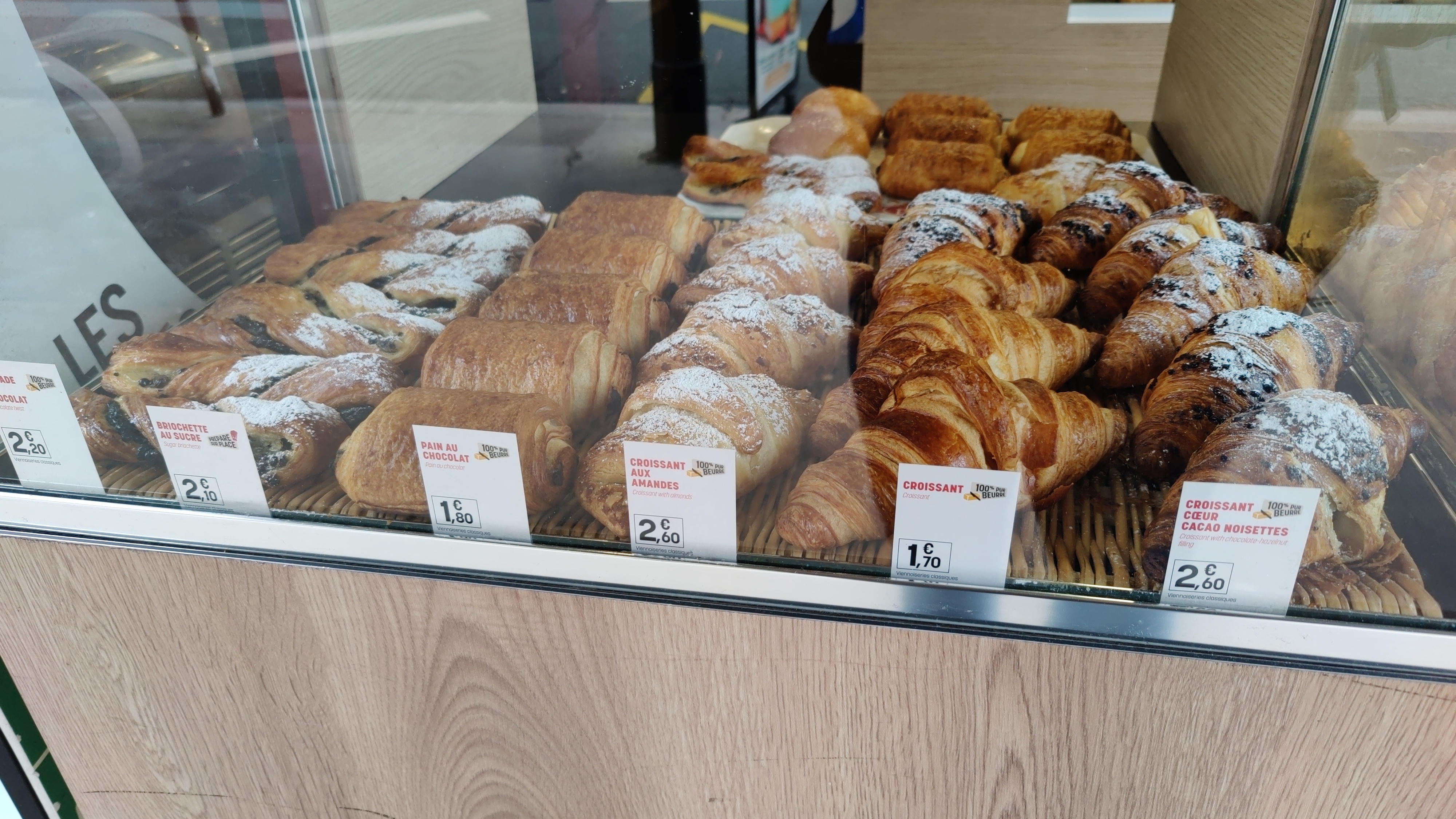 Items from left to right are: Chocolate Twist, Sugar briochette, Pain au Chocolat, Croissant with almonds, Croissant, Croissant with chocolate hazlenut filling.Items at a bakery in Paris