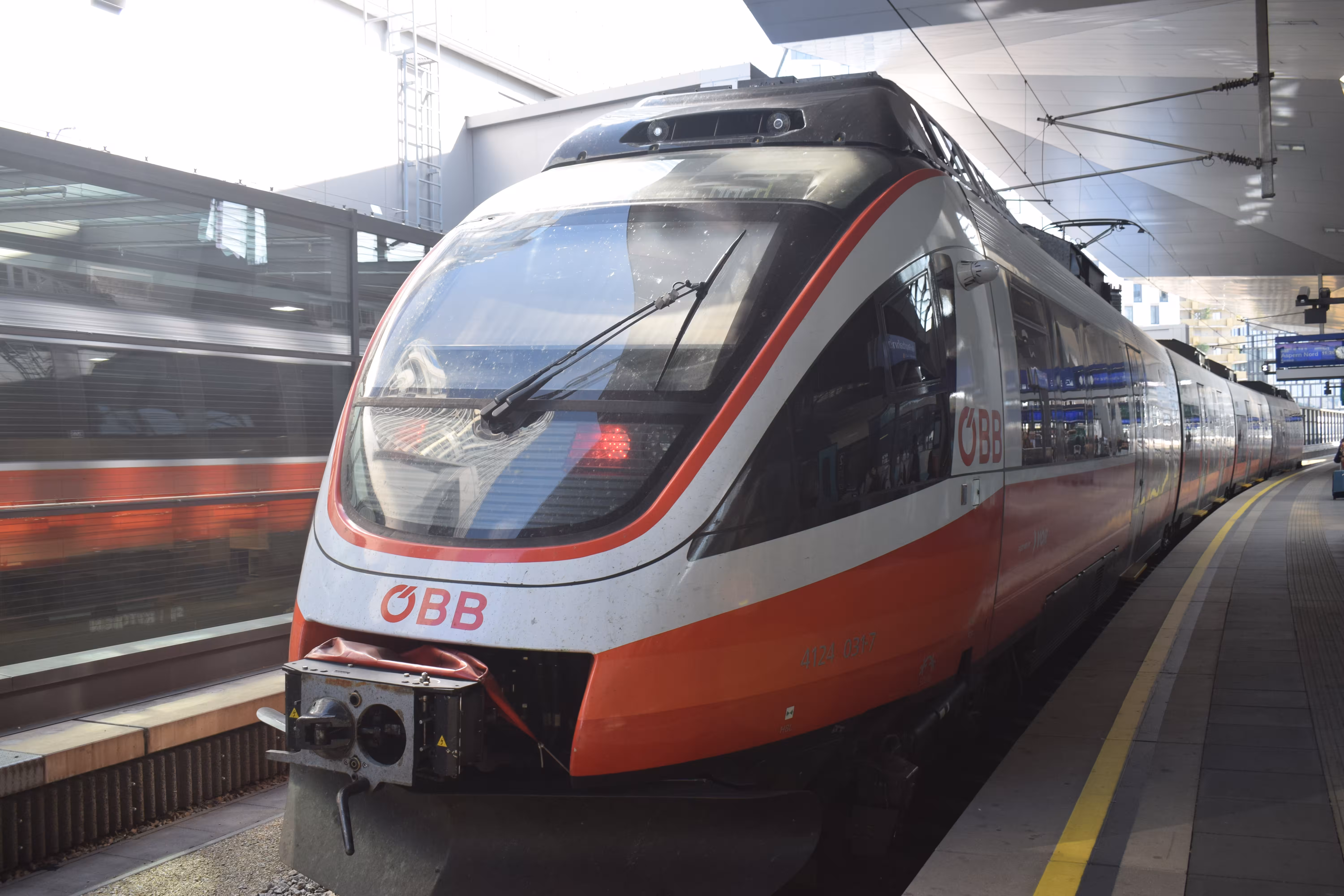 A red colored train standing at the Vienna station