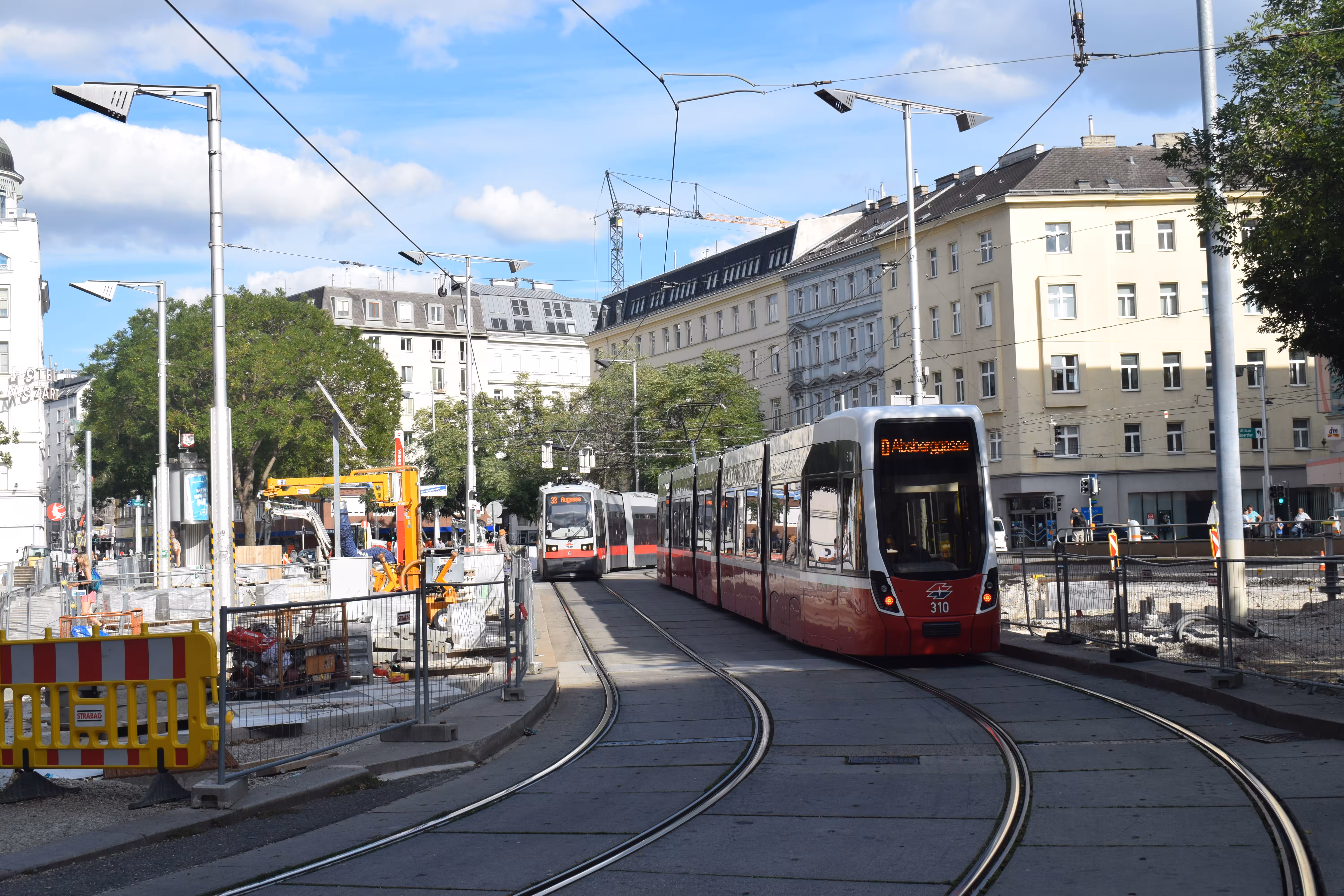 Trams with buildings and the blue sky in the background